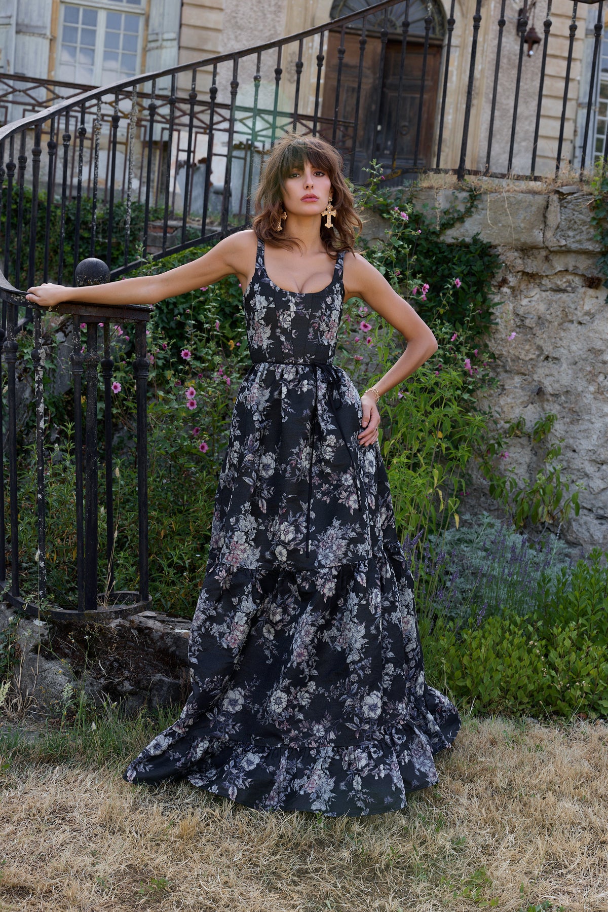Front view of The Avery Dress in Black Lilibet Brocade with a corseted scoop neck and gathered tiers on a model