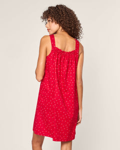 A woman with curly hair wears Petite Plumes Womens Twill Annabelle Nightgown in Anchors Away, a sleeveless red dress with a gathered back and small white floral pattern, standing against a plain backdrop, evoking luxury cotton sleepwear.