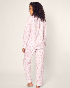 A person with curly hair wears the Petite Plume Womens Twill Pajama Set in Seashell Splendor, made from luxurious cotton sleepwear. It features a soft, comfortable design crafted to perfection against a plain, light background.