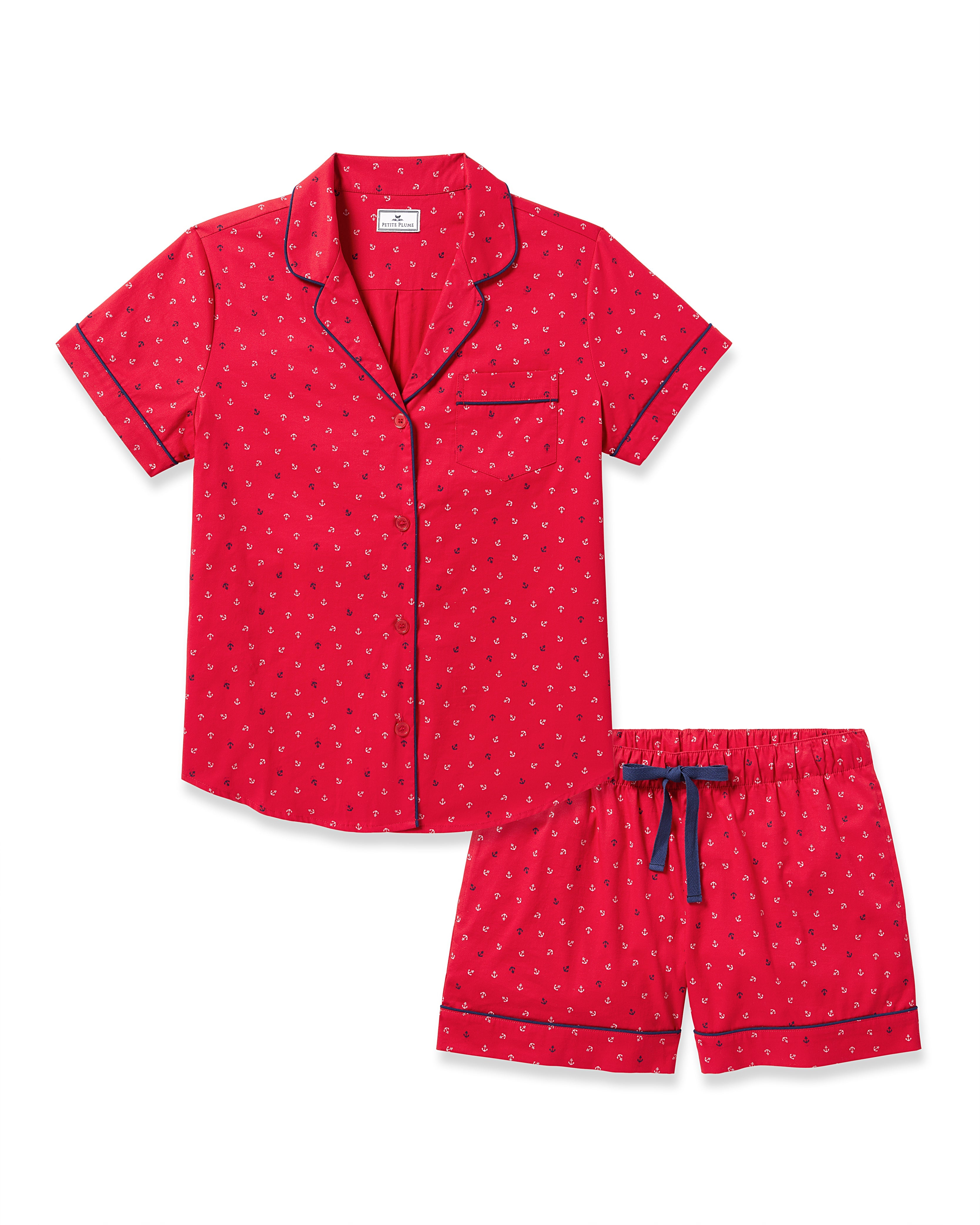 The Womens Twill Short Sleeve Short Set in Anchors Away by Petite Plume features a red pajama set with a dotted pattern, and includes a short-sleeved button-up shirt and shorts with navy blue trim and drawstring, crafted from luxe cotton for luxurious sleepwear.