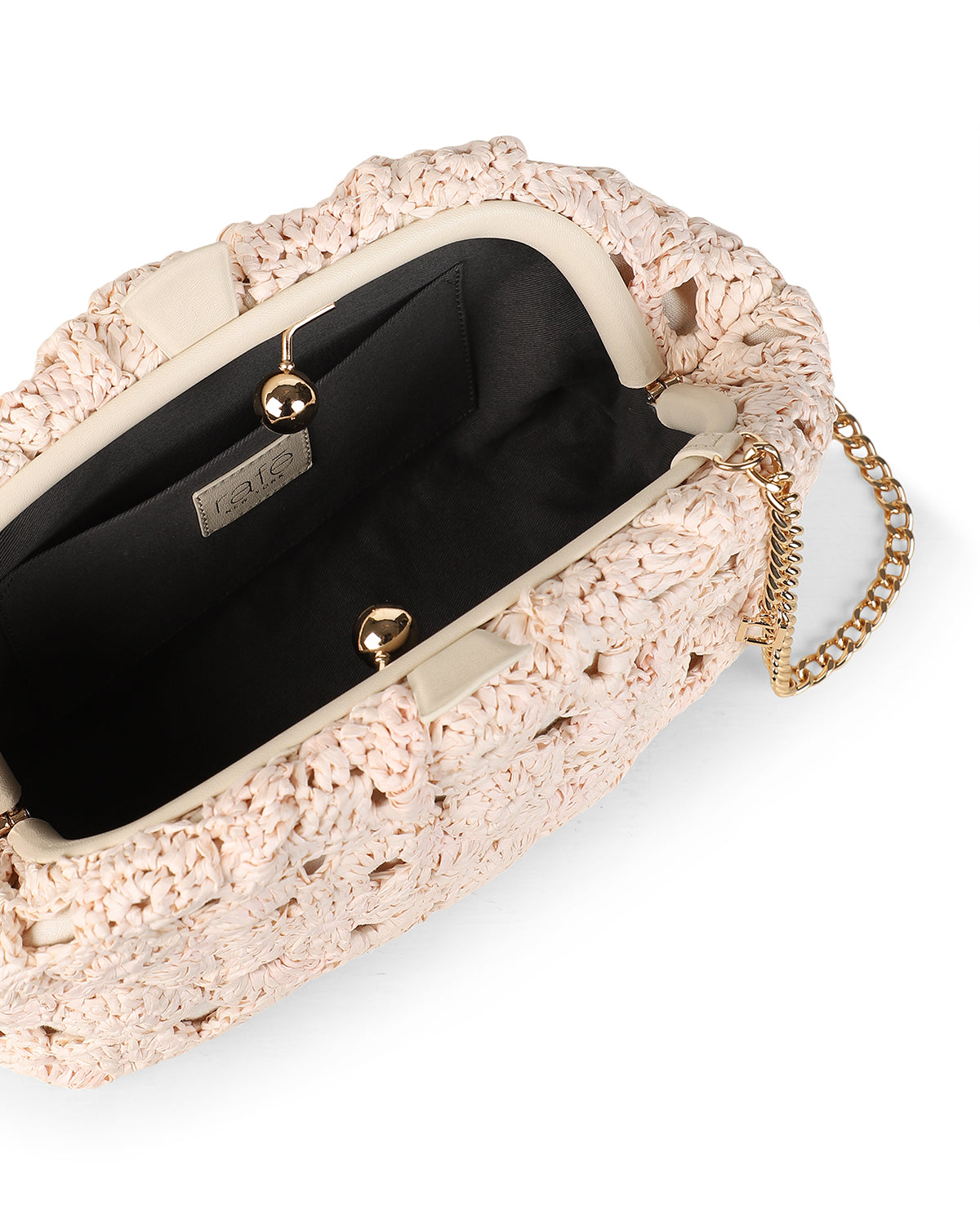 Top view of Aya Clutch in Natural/Ivory showing floral raffia crochet, open black lined interior, gold clasp and chain strap