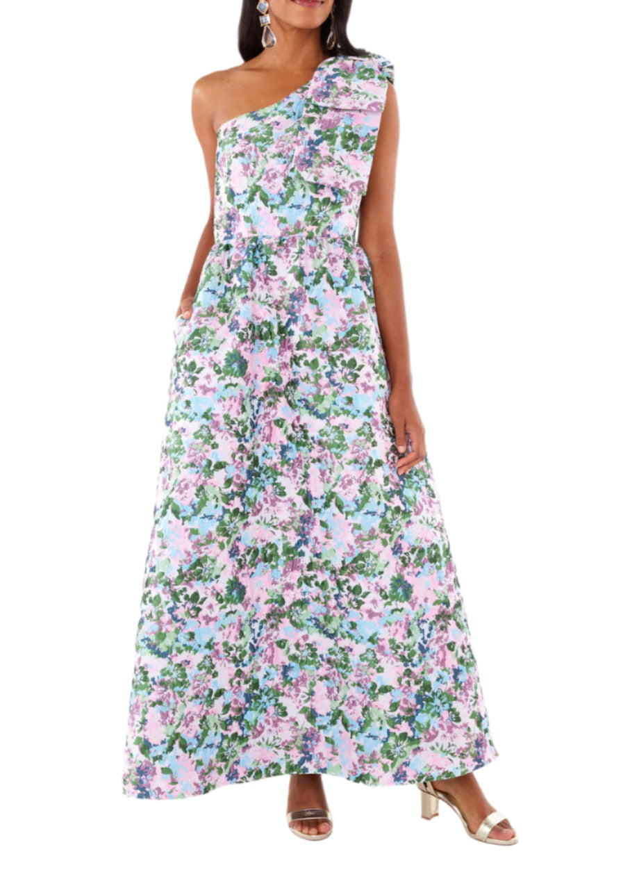 Front view of pink floral Caroline Gown showcasing one-shoulder bow and A-line silhouette on model against white background