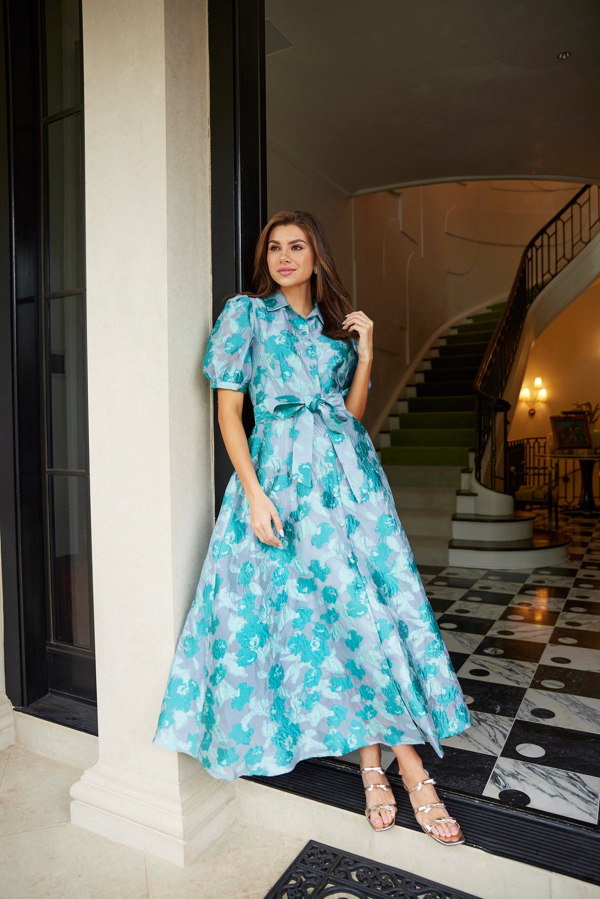 Front view of Charlotte Gown Mint Rose Vine Organza showcasing collared neckline and self tie belt in an elegant interior