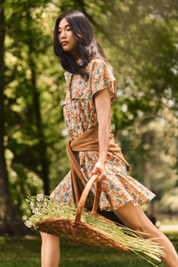 The Addison Dress, Made with Liberty Fabric floral dress, carrying a basket of florals.
