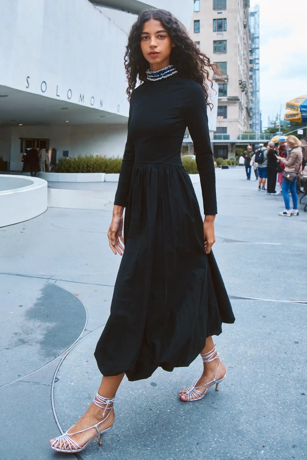 The Alexandra Dress is a fitted bodice with long sleeves, bubble skirt, and jeweled trim neckline. 