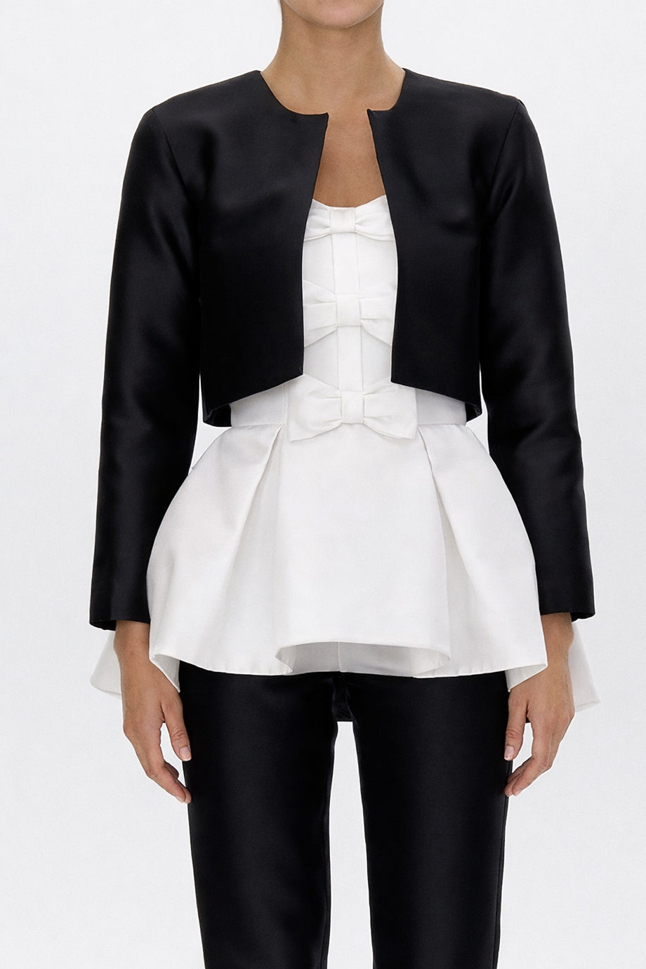 Front view of Carolyn silk and wool cropped jacket showing open-front silhouette and smooth black finish on model