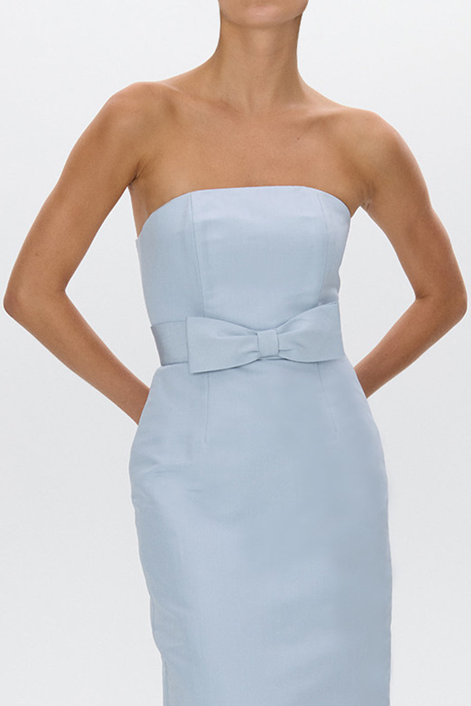 Front of Elizabeth Silk Faille midi dress on model, strapless with waist bow belt and fitted silhouette on gray background