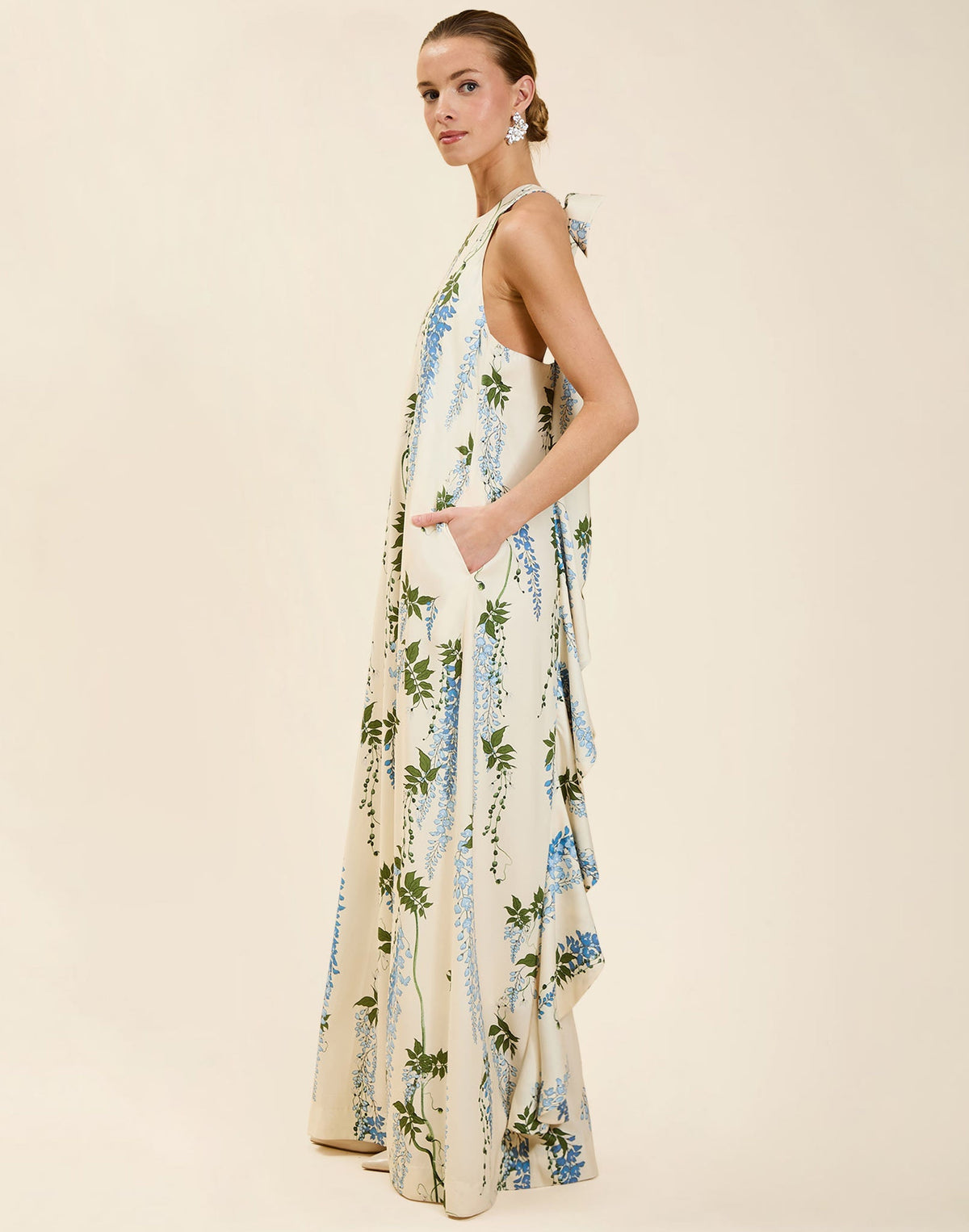 Adelina Gown in Wisteria Toile stretch crepe with halter neckline, cascading bow back detail, A-line silhouette, and hidden side pockets.