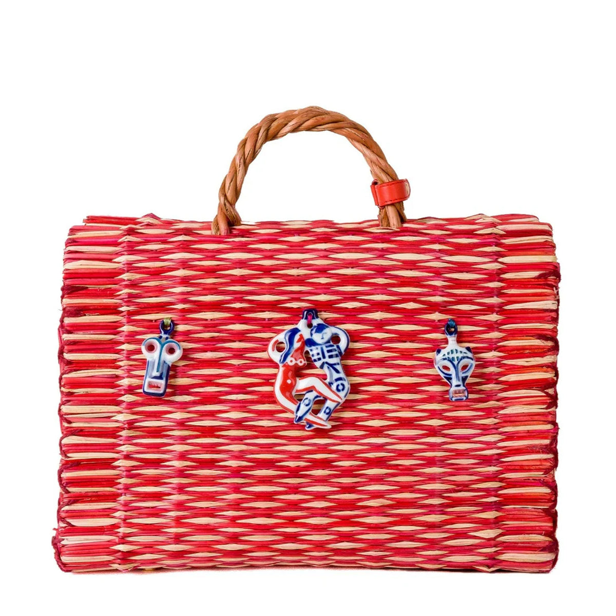 Front view of Amor large basket bag showing red-and-natural woven reeds, three porcelain charms, braided leather handle on white