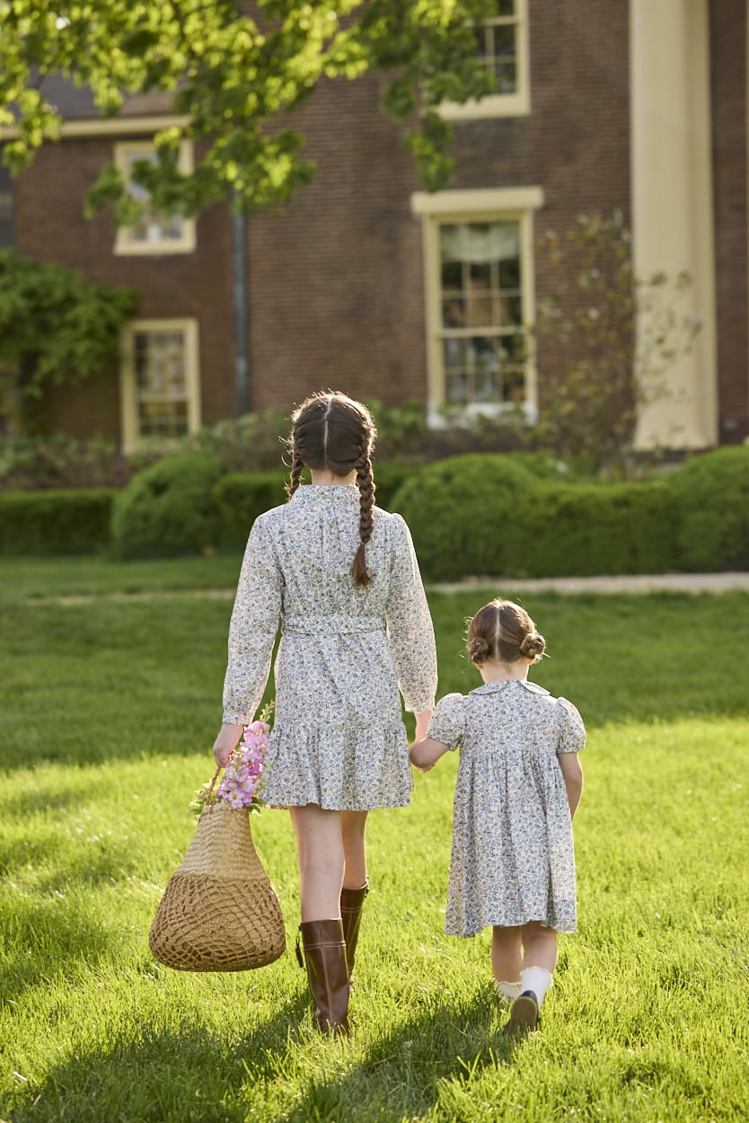 Little English traditional children's clothing. Long sleeve blue, brown, and cream floral shirt dress with tie sash for older girls.