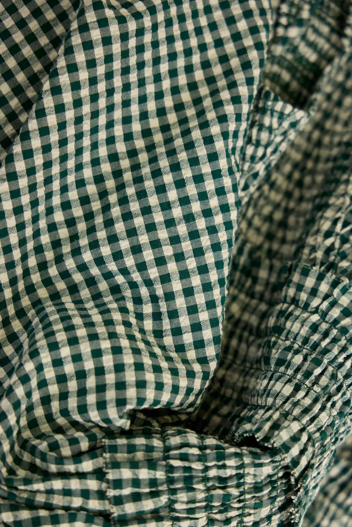 The Eubanks Top has a fitted bodice, puff sleeves, smocked cuffs, shirred yoke, and purl edge trim.