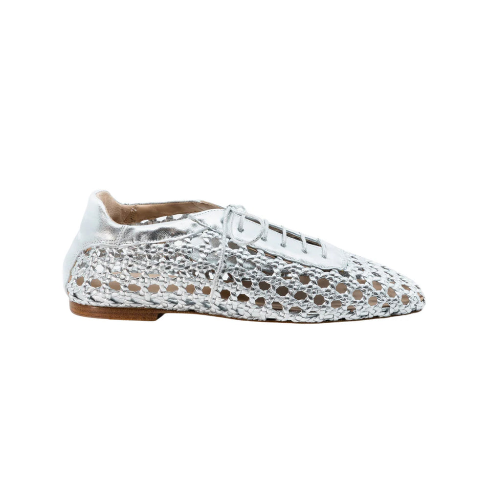 Side view of Antonia flat in leather showcasing woven metallic silver upper and low stacked brown sole on white background