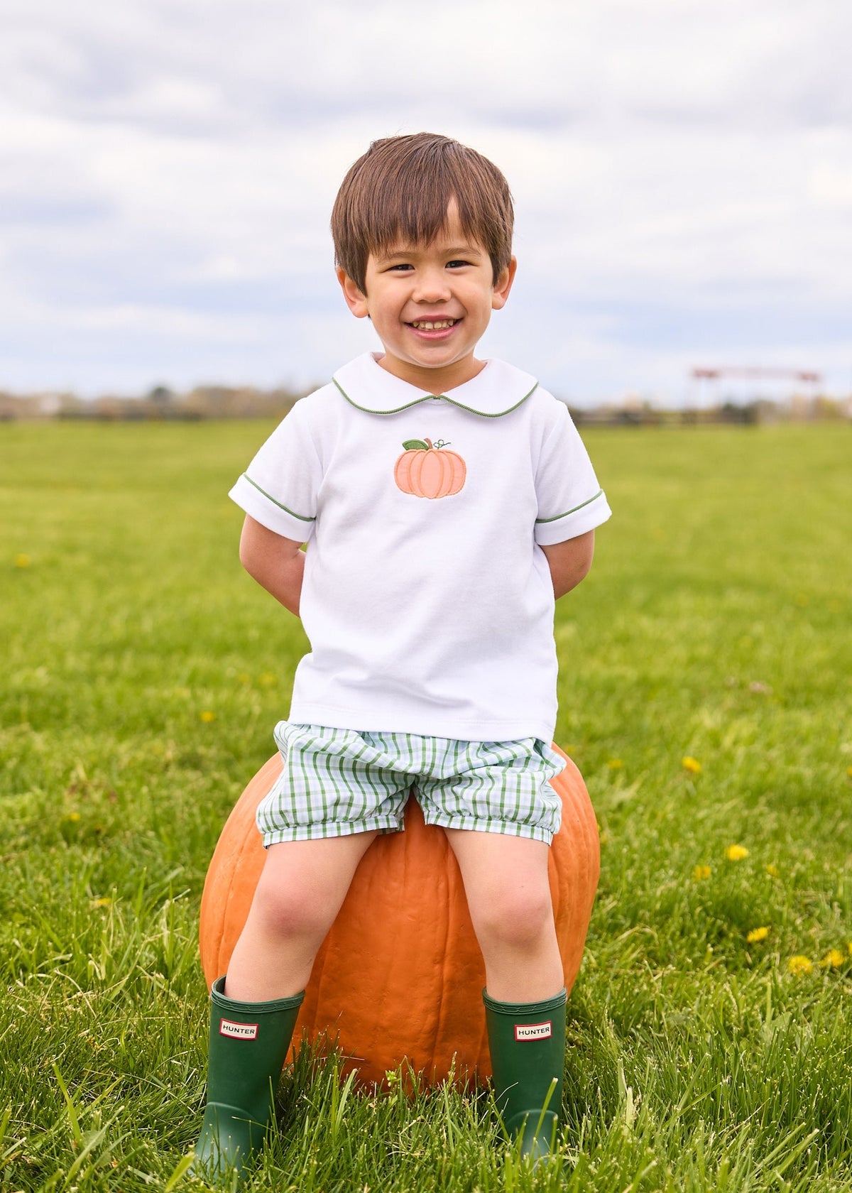 Little English classic short set for little boys.  White knit peter pan shirt with applique pumpkin at the center and coordinating banded shorts in green Leland Plaid.  