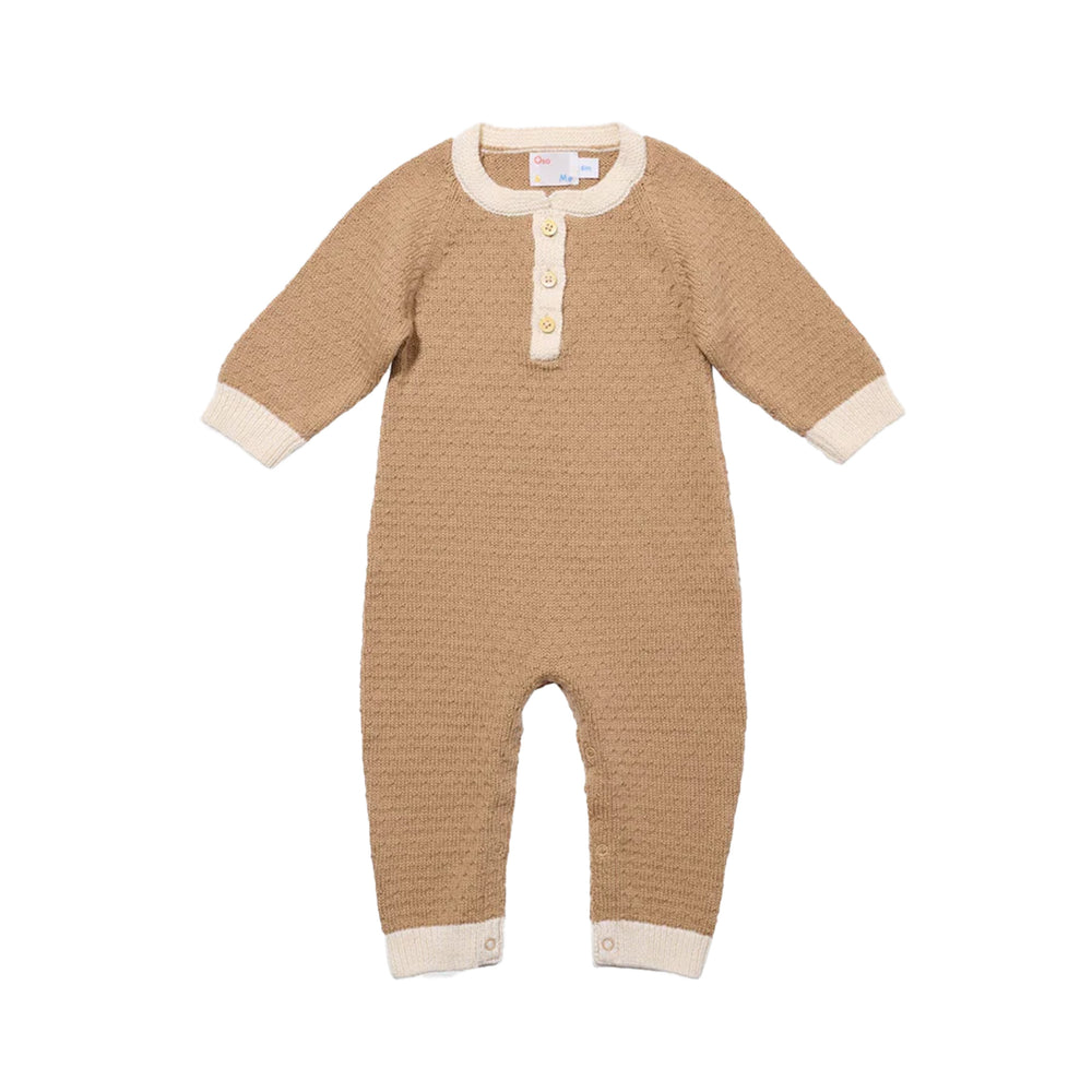 Front view of Archie jumpsuit in camel showcasing waffle-knit merino cotton blend, cream contrast cuffs and collar, and snap leg closures on white background