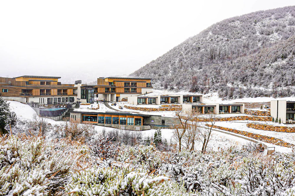 The Lodge at Blue Sky resort set on a snowy hillside, showing modern wood-and-stone buildings and terraced guest rooms