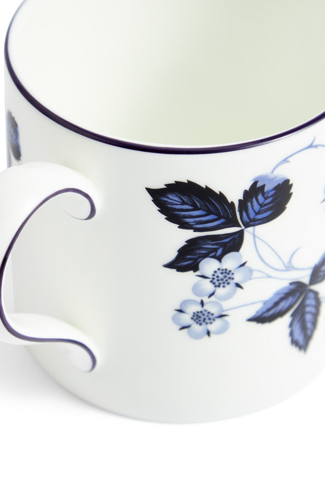Close-up side view of Wild Strawberry Inky Blue Mug showcasing blue botanical design on white fine bone china
