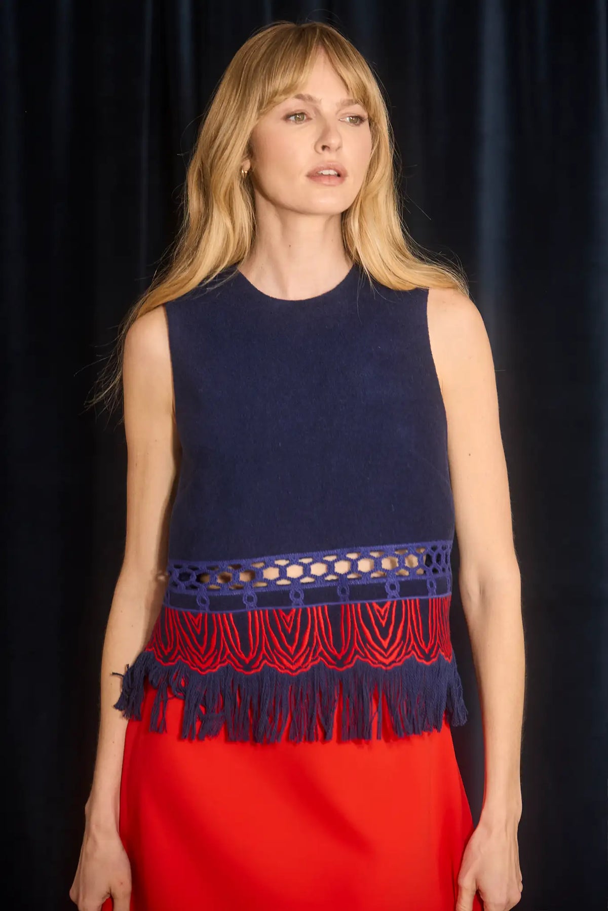 The Astor Top is designed with a crew neckline, button keyhole closure, and sleeveless silhouette.