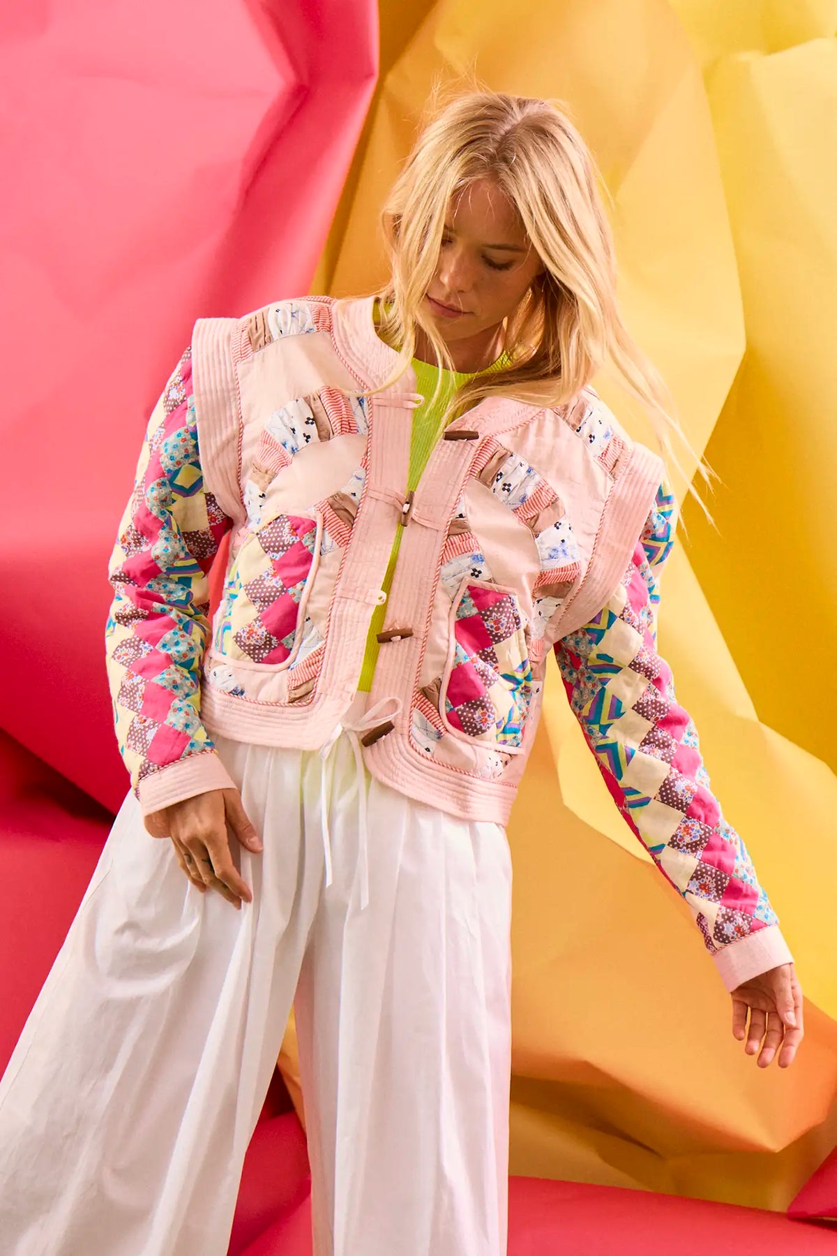 A cropped long-sleeve quilted jacket with a wooden toggle closure in multiple pastels.