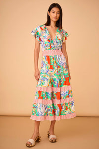 The Aurora Dress has a low-cut wrap ruffle neckline, rope ties, skirt ruffles, and a smocked waist.