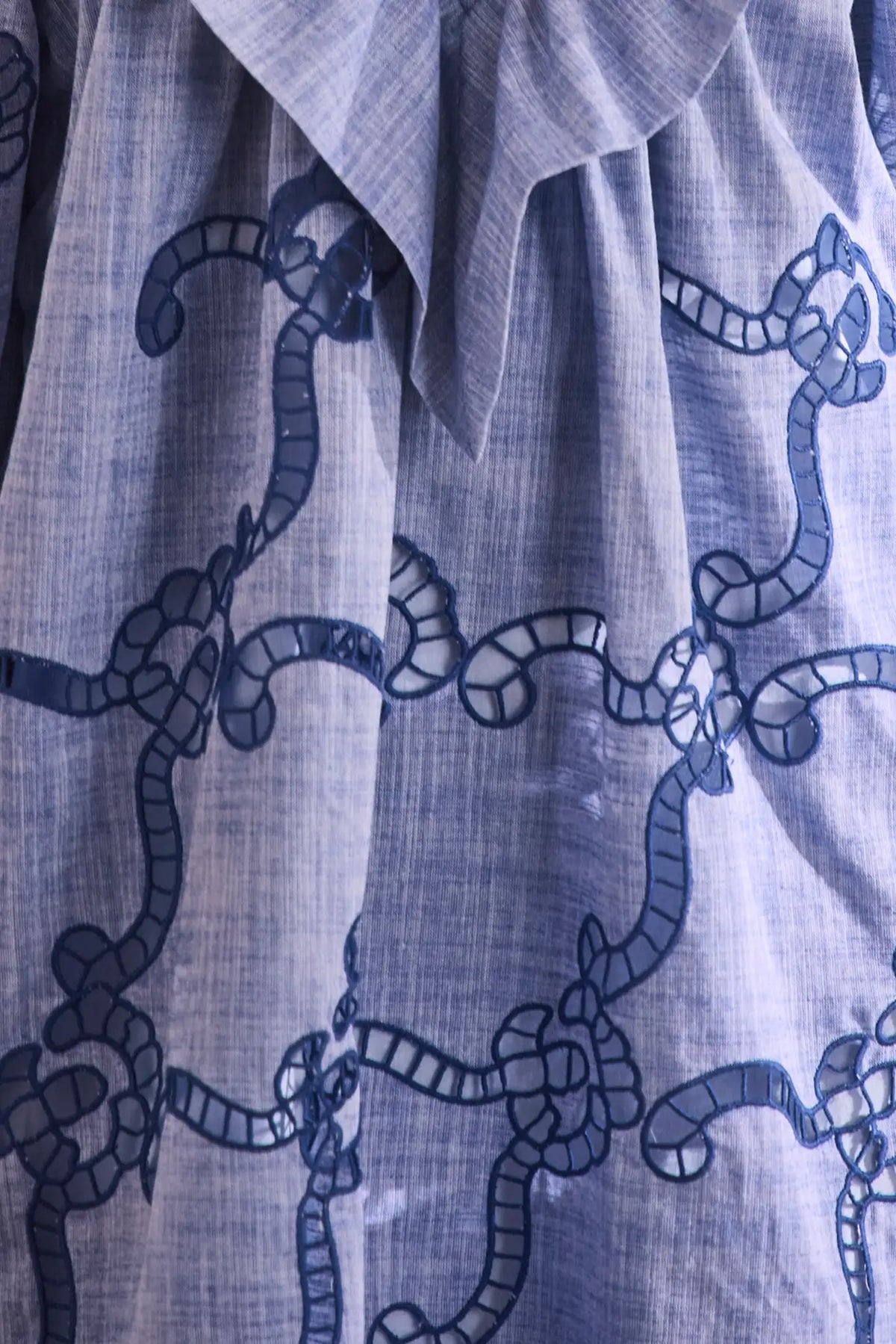 Blue cut-out embroidered linen, crew neckline, softly ruffled yoke, long sleeves with button cuffs