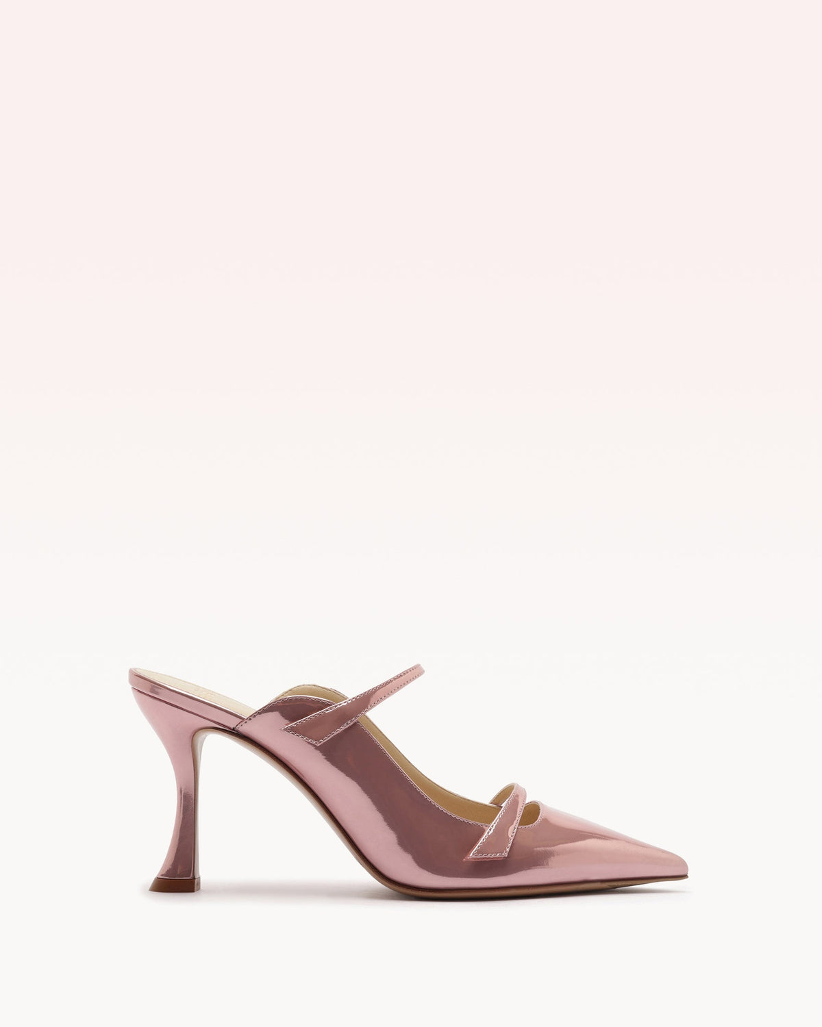 Side view of Tita Mule 85 in pink showing sculptural flared heel and pointed toe on pale gradient background