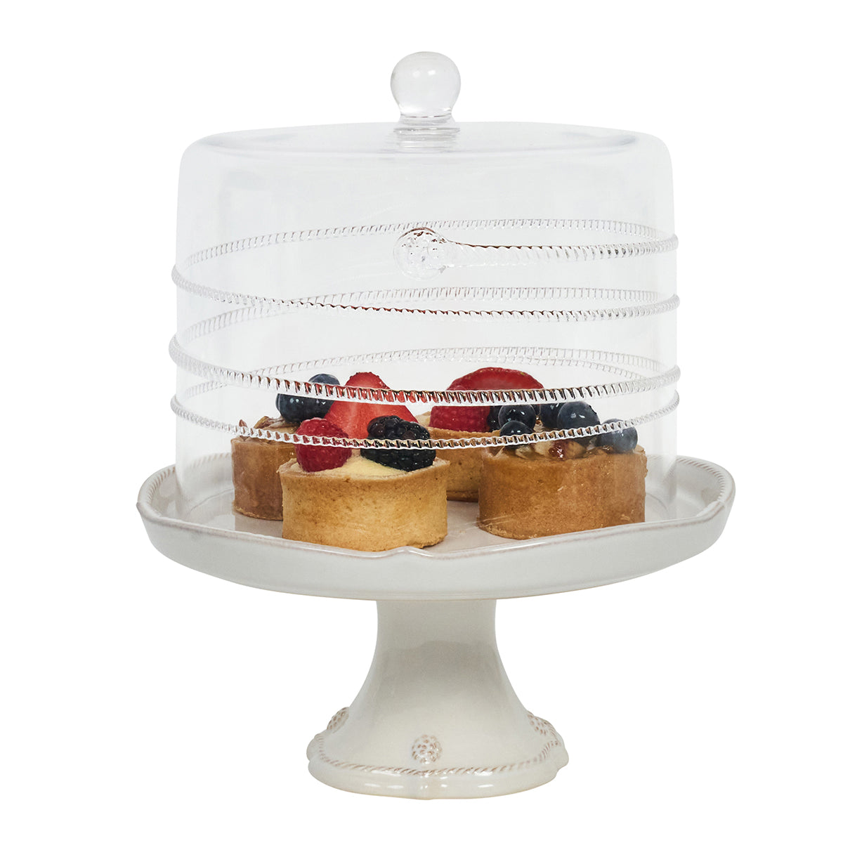 Front view of Amalia Petite Cake Dome in clear mouth-blown glass with spiral swirl detail on a white pedestal containing small tarts