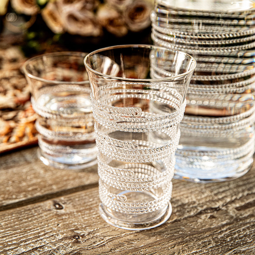 Angled front view of Ella large tumbler showcasing spiraling beaded thread detail on clear glass on a wooden table