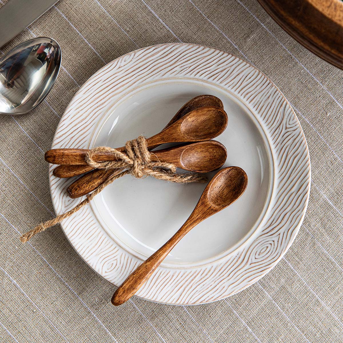Overhead view of Bilbao Wood Petite Spoons showcasing mango wood with a white plate and checked tablecloth background