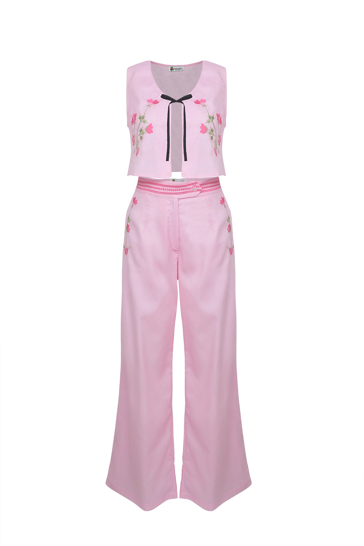 Front view of Betul set: pink cropped top with floral embroidery and black bow, high-waist wide-leg pants on white