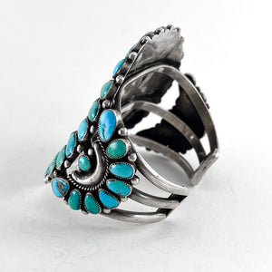 Angled view of Vintage Zuni Cluster Bracelet showcasing natural American turquoise stones in sterling silver with white background