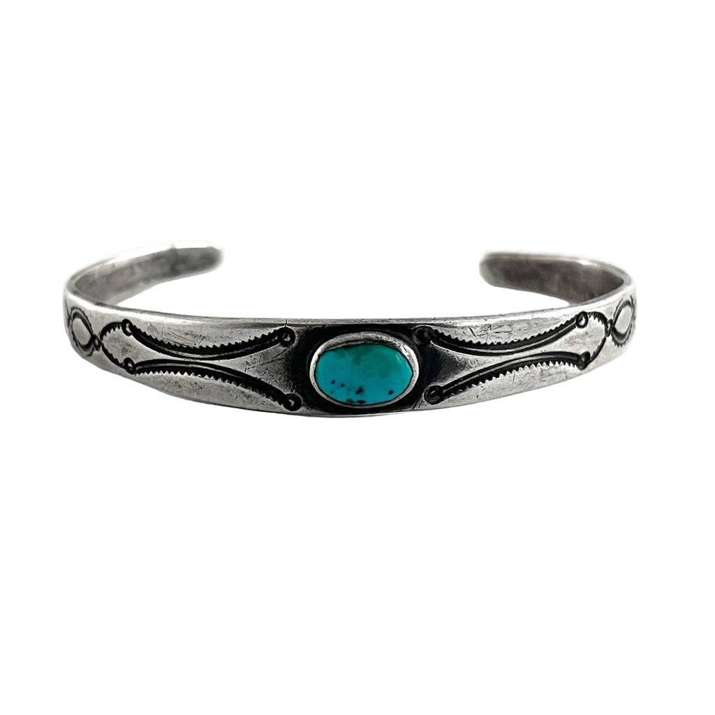 Front view of vintage single stone bracelet showing oval American turquoise, plain silver bezel, and engraved open cuff