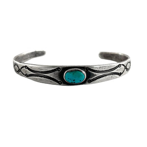 Front view of vintage single stone bracelet showing oval American turquoise, plain silver bezel, and engraved open cuff
