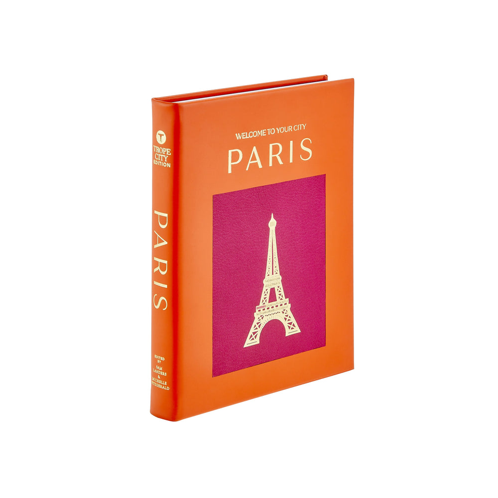 Angled front view of Trope Paris book with orange leather cover, gold PARIS title and Eiffel Tower on magenta inset on white