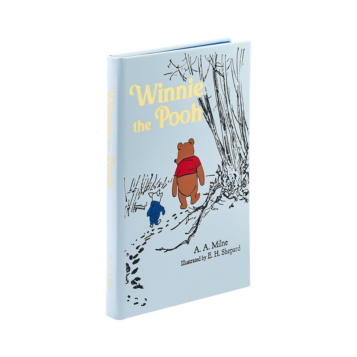 Three-quarter view of leather-bound Winnie the Pooh edition with light blue cover, gold-embossed title and E H Shepard illustration