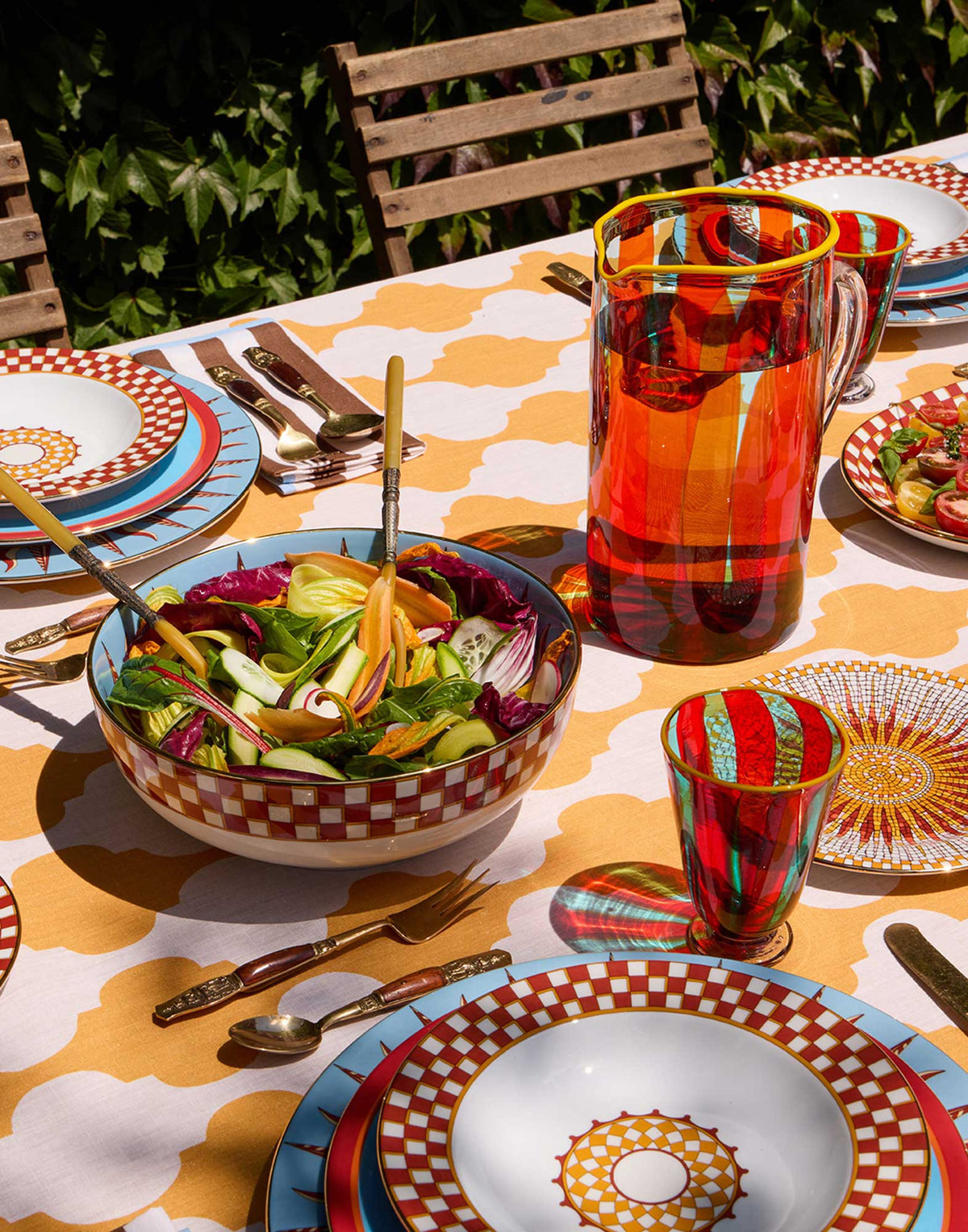 Apollo Mattone serving bowl filled with salad in a colorful outdoor table setting