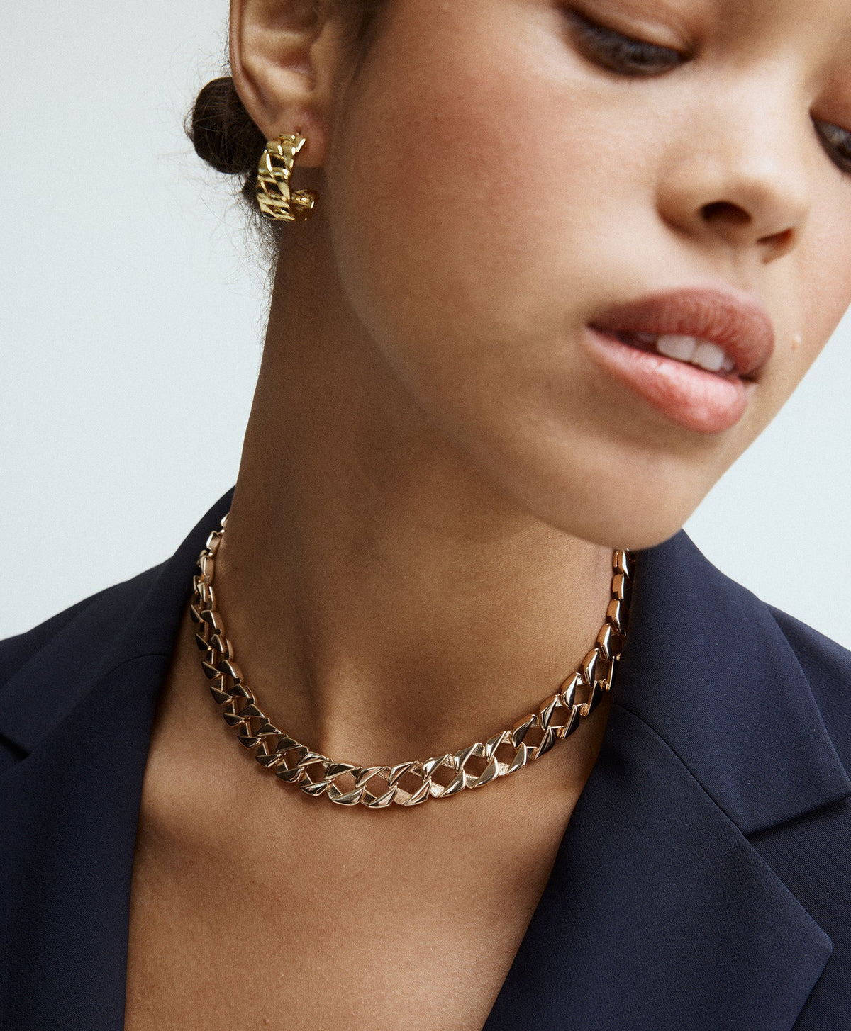 Close-up view of Babe Earrings showcasing gold tone link hoops on a model wearing a matching necklace