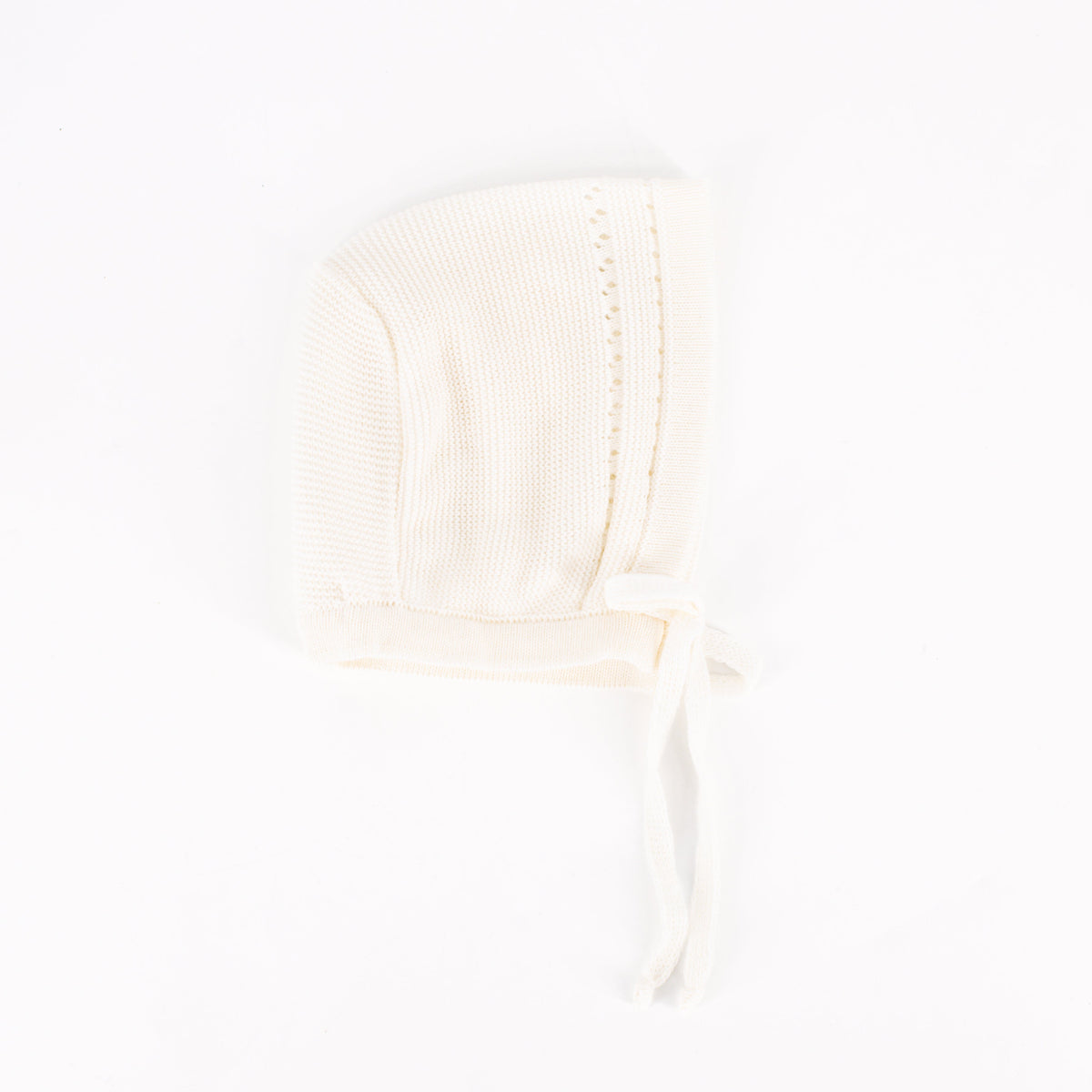 Close-up view of Knit Baby Bonnet in Ivory showcasing its knit texture and tie fastening on a white background