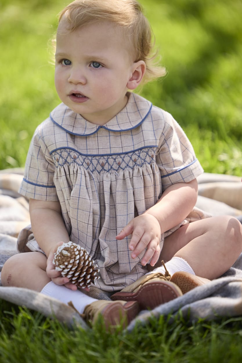 Little English classic children's clothing.  Smocked peter pan bubble in tan and blue Durham windowpane with blue piping for baby boys
