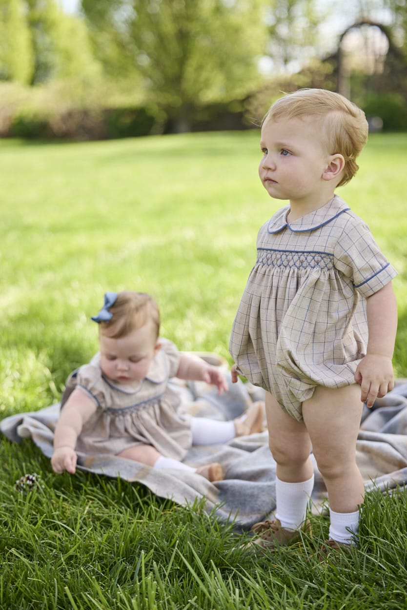 Little English classic children's clothing.  Smocked peter pan bubble in tan and blue Durham windowpane with blue piping for baby boys