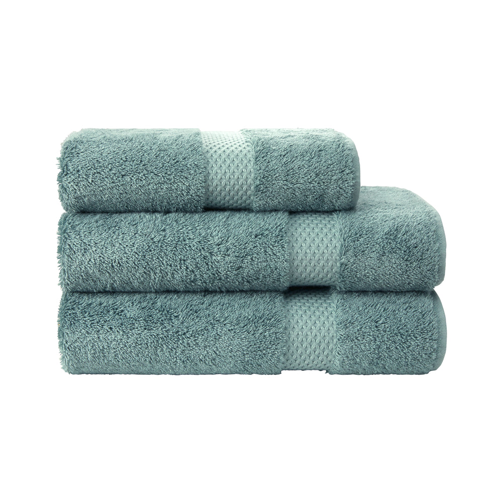 Stacked front view of Etoile bath sheets in fjord teal showing plush pile and textured star-pattern band on white background