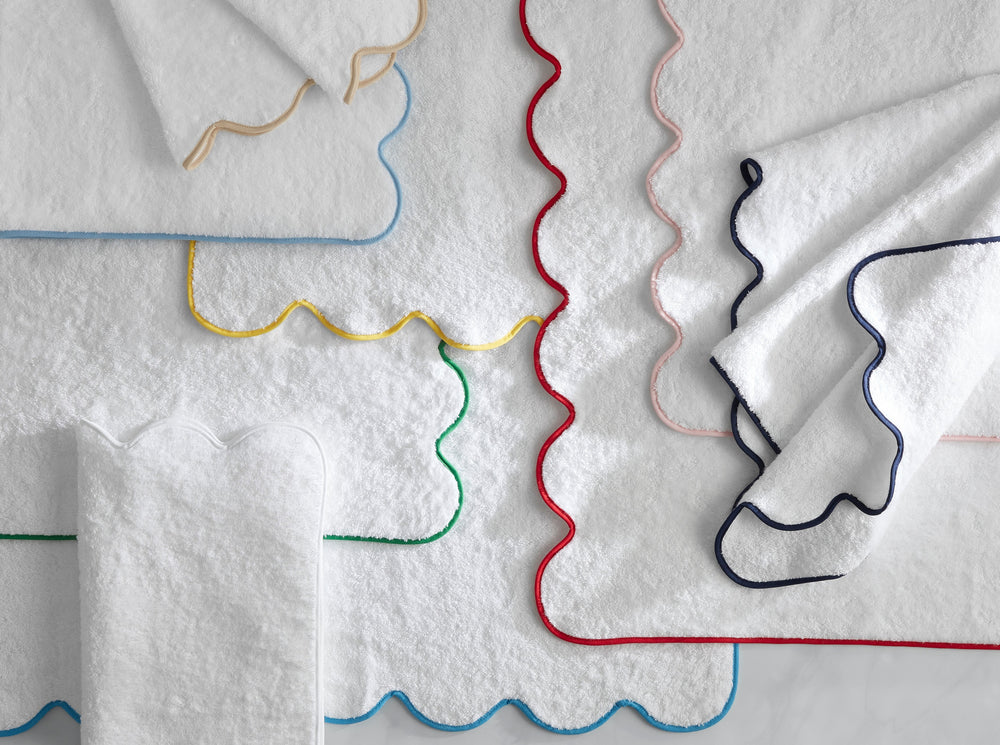 Overhead view of Cairo scallop bath towels showing white terry cloth with scalloped edges and colorful contrast trim