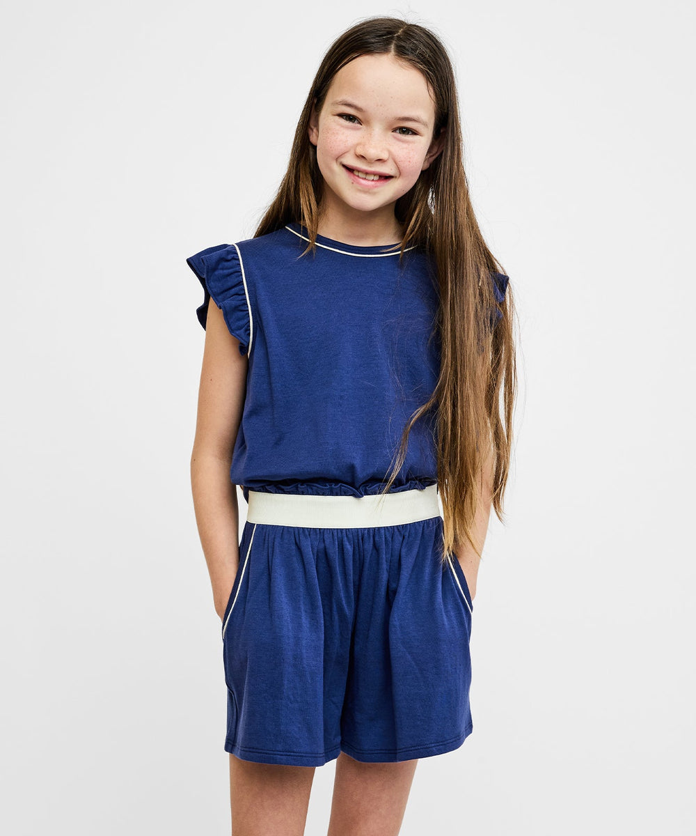 Front view of Bea Short Set in navy on child model showing ruffle sleeves, contrast elastic waist and side pockets
