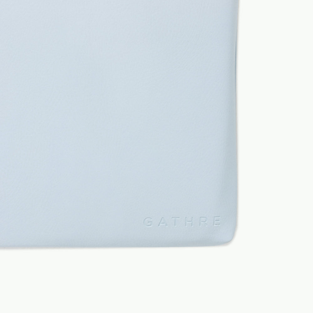 Close-up of Padded Changing Mat showing debossed GATHRE logo on light blue wipeable faux-leather surface