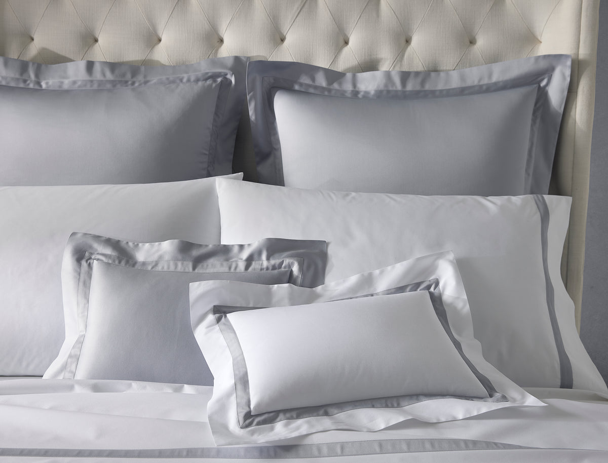 Front view of Nocturne sham in dove showing contrast gray border and sateen finish on a tufted headboard