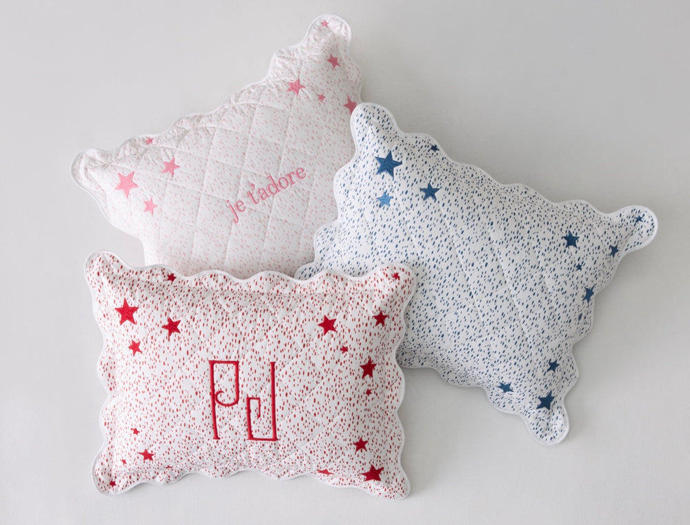 Three-quarter view of three Celine Stars mini boudoir pillows (pink, prussian blue, redberry) showing scalloped edges and star print on a pale background