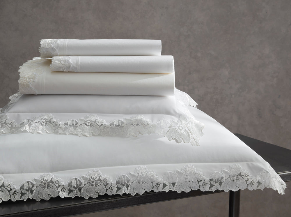 Stacked view of Virginia bedding set showcasing white sheets and pillowcases with floral lace trim on a gray backdrop