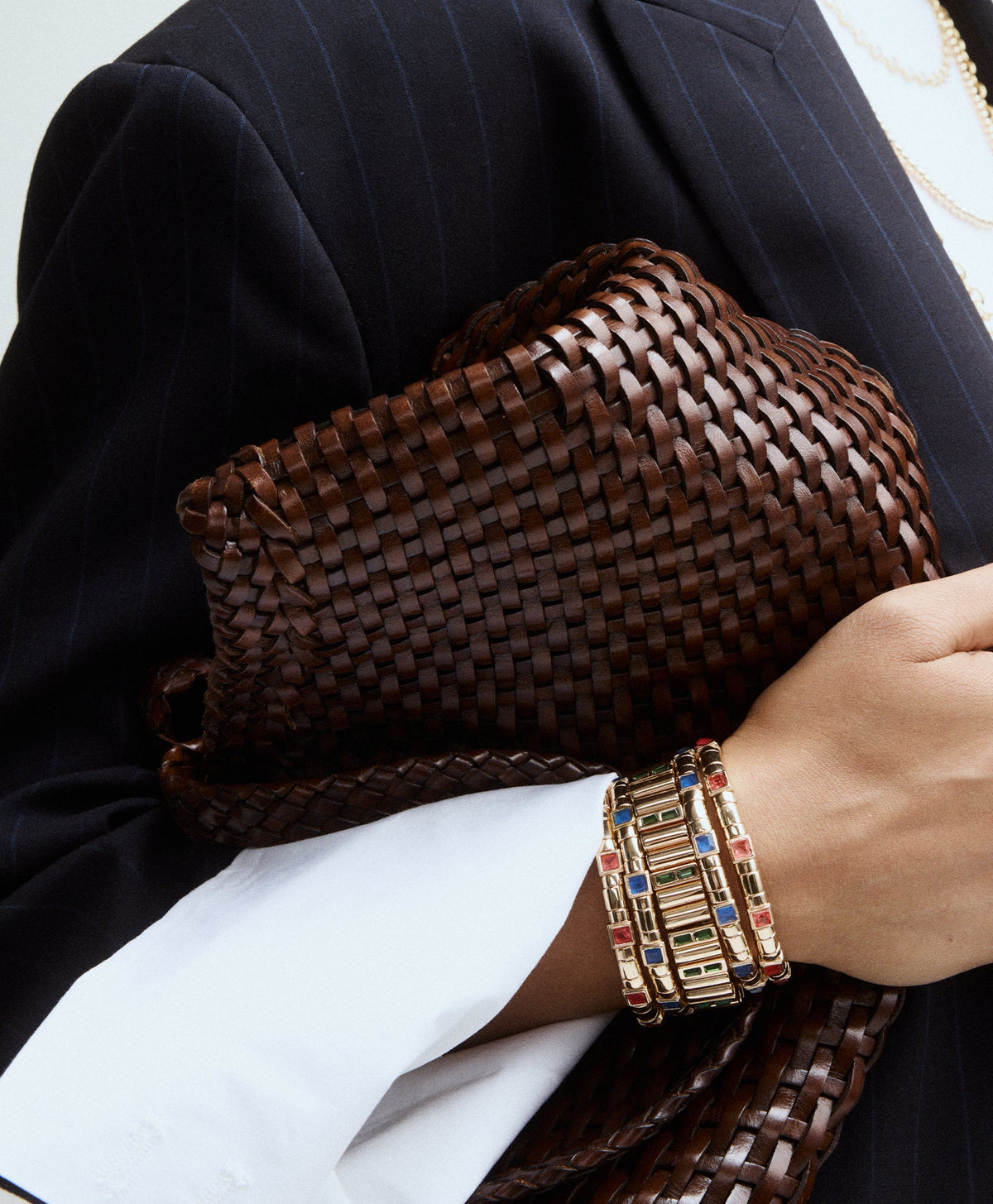 Close-up of Bejeweled Bracelets showcasing colorful glass stones on gold toned bands, worn on a wrist