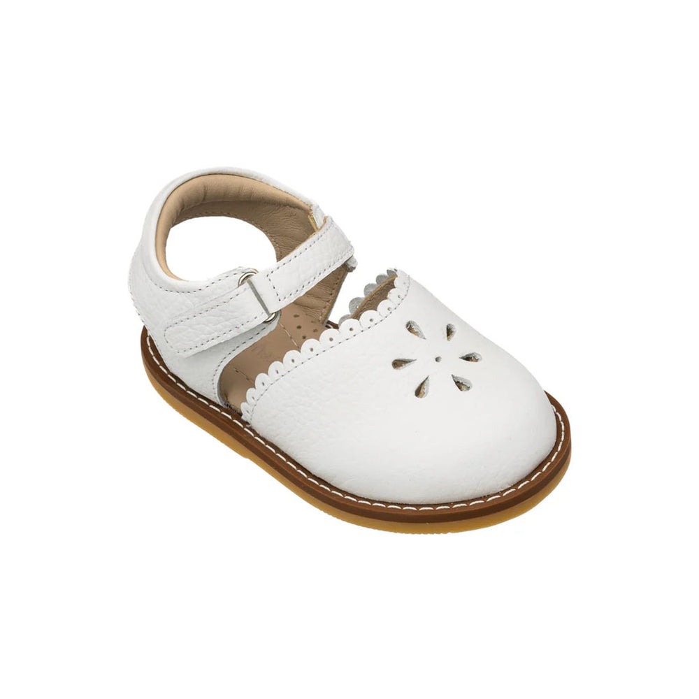 Front three-quarter view of Bellis toddler sandal showcasing scalloped edge, flower cutouts, ankle strap, white leather on white background