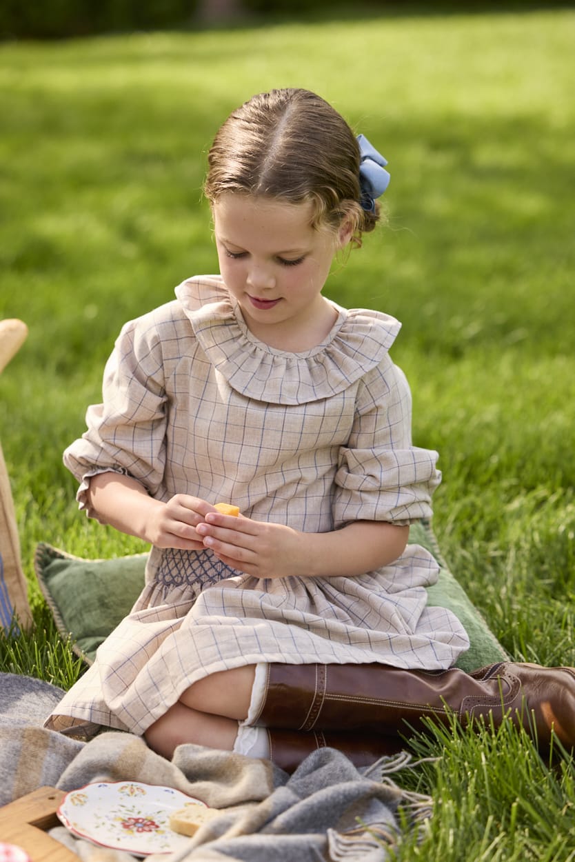 Little English traditional children's clothing.  Long sleeve blouse in tan and blue Durham Windowpane with a ruffled collar paired with matching skirt with blue smocked waistband for girls