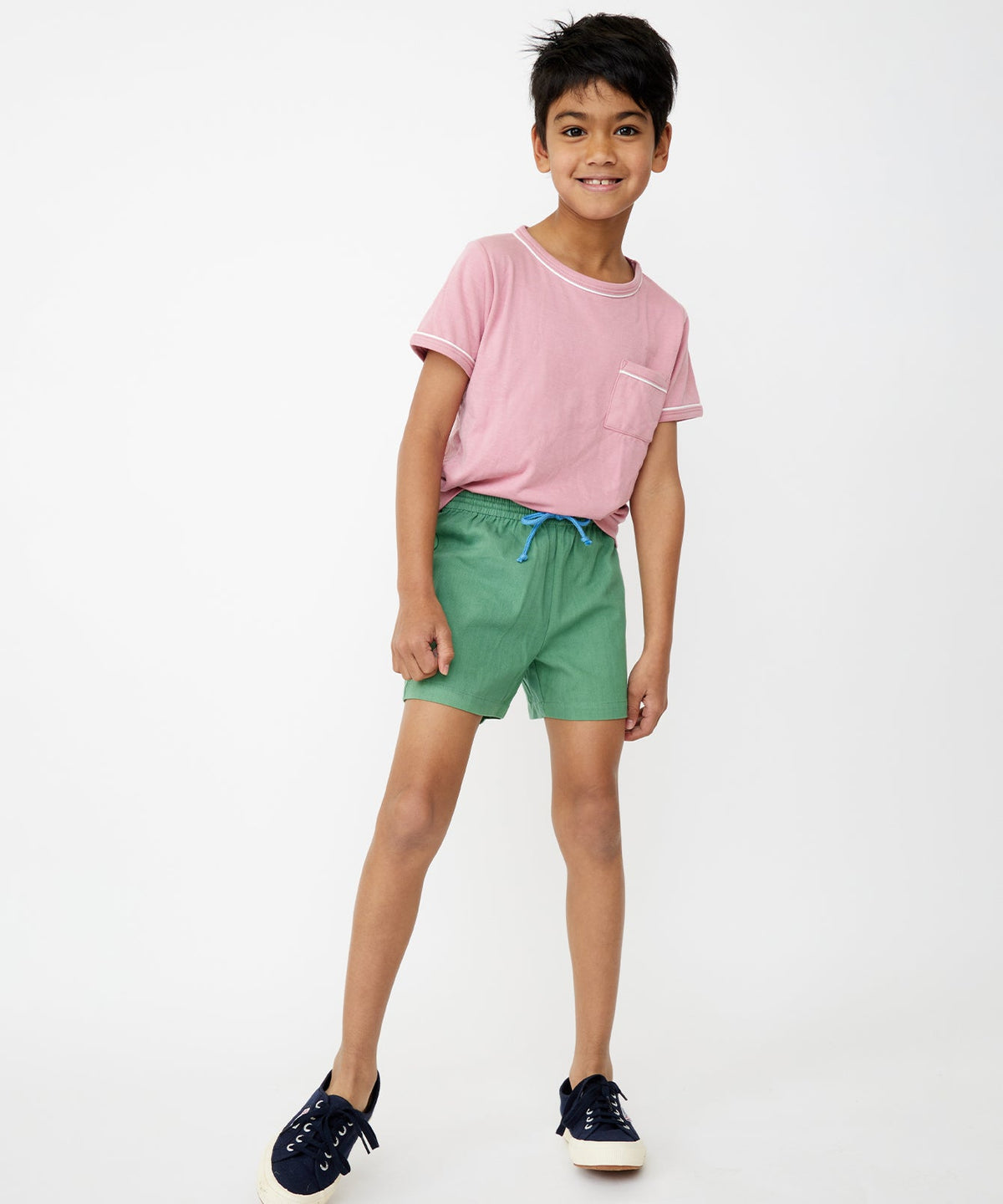 Three-quarter view of Bingo Short in Green showcasing shorter inseam and contrast drawcord on child model, white backdrop